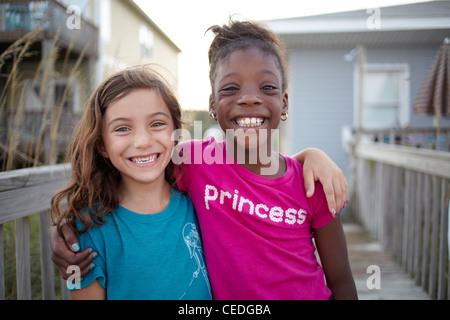 Grinning girls hugging outdoors Banque D'Images