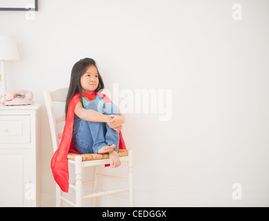 Fille coréenne au cap sitting on chair Banque D'Images