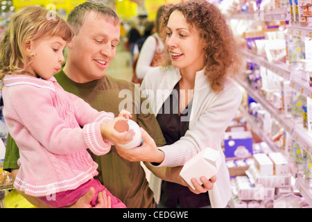 Famille avec petite fille acheter du lait au supermarché Banque D'Images