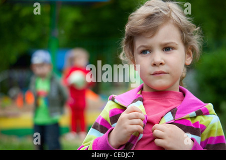 La fille joue dans la cour de la maternelle Banque D'Images