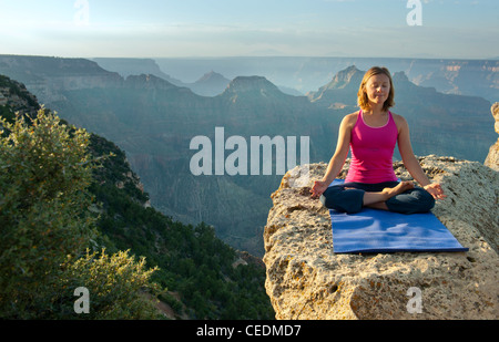 Caucasian woman practicing yoga on falaise près de canyon Banque D'Images