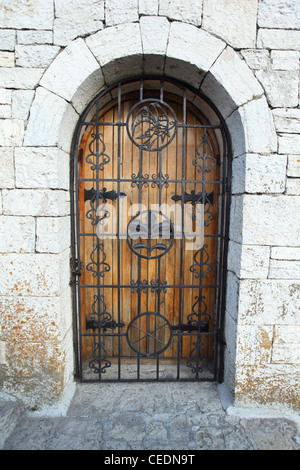 Porte derrière lattice dans mur de pierre Banque D'Images