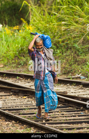 Homme marchant sur la ligne de chemin de fer de Badulla à Colombo, une chose commune dans les hauts plateaux du centre, près de Ella, Sri Lanka, Asie Banque D'Images