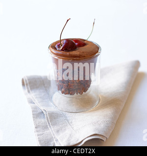 Rice crispie gâteau à la mousse au chocolat et cerises au kirsch servi en verre, close-up Banque D'Images