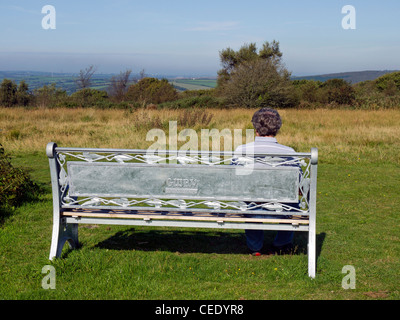 L'homme sur un banc de profiter de la vue de Bodmin Beacon réserve naturelle locale dans la région de Cornwall. Banque D'Images