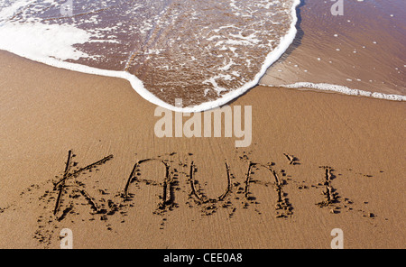 Kauai écrit dans le sable sur la plage avec des vagues de la mer à partir d'effacer le mot Banque D'Images