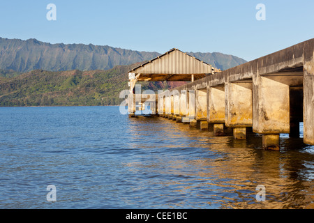 Soleil levant éclaire la jetée d'Hanalei et montagnes de Na Pali à Kauai Banque D'Images