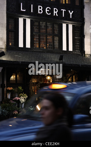 L'Liberty store à Londres avec une personne et un taxi passant Banque D'Images