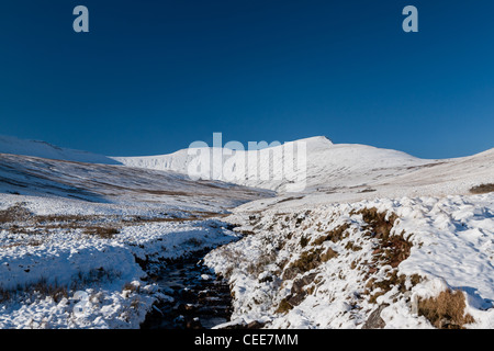 Une petite rivière s'écoule à partir de blanc, des montagnes enneigées au loin Banque D'Images