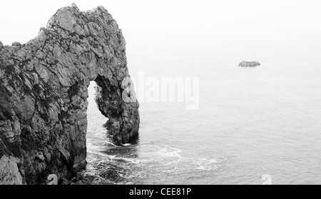 Le noir et blanc Durdle Door Coastal Rock Arch dans le calme sur la Crique de Lulworth côte britannique Banque D'Images