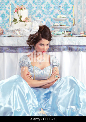Licence et tirages sur MaximImages.com - magnifique femme asiatique dans une robe bleue fantaisie à une fête de thé avec une table de fête Banque D'Images