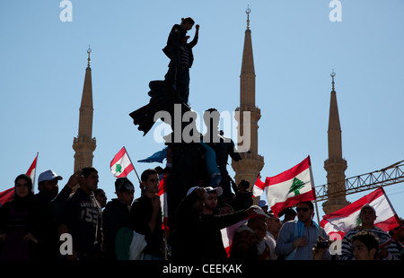 Partisans politiques avec les drapeaux escalader Place des Martyrs monument à Beyrouth, au Liban. Minarets surplombent les lieux Banque D'Images