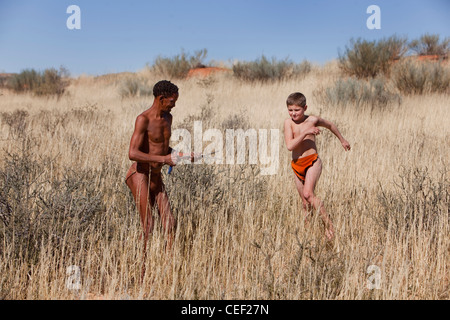 Garçon blanc et un bushman dans Kagalagadi Transfrontier Park, Xaus camp, Afrique Namibie Banque D'Images