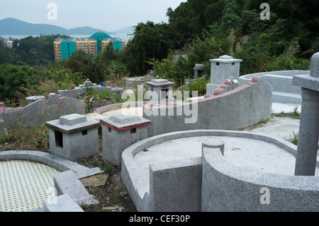 dh PENG CHAU ISLAND HONG KONG Hillside tombes chinoises surplombant la communauté de nouveaux appartements cimetière de la famille de tombes pierres tombales Banque D'Images