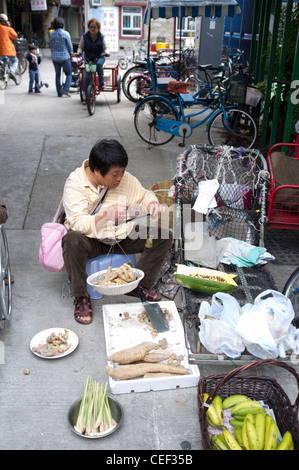 Dh Tung Wan Peng Chau ISLAND HONG KONG Chinese woman street vendeur à l'aide de balances à main street Banque D'Images