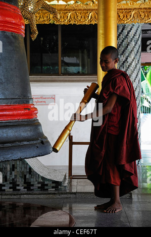 Moine bouddhiste robe rouge bell sonnerie sonnerie méditer la méditation de la pagode Shwedagon à Yangon Myanmar Birmanie Rangoon monument historique Banque D'Images