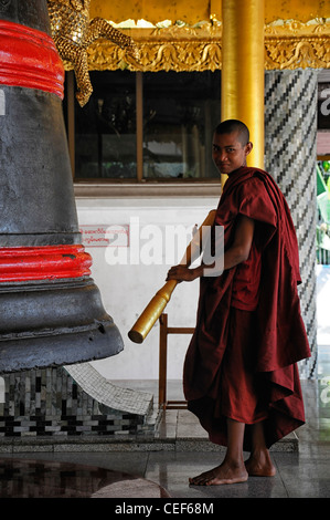 Moine bouddhiste robe rouge bell sonnerie sonnerie méditer la méditation de la pagode Shwedagon à Yangon Myanmar Birmanie Rangoon monument historique Banque D'Images