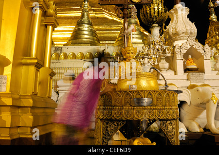 Fervent pèlerin pour verser de l'eau faisant offrande à Bouddha statue post planétaire de la pagode Shwedagon de nuit myanmarnight Banque D'Images