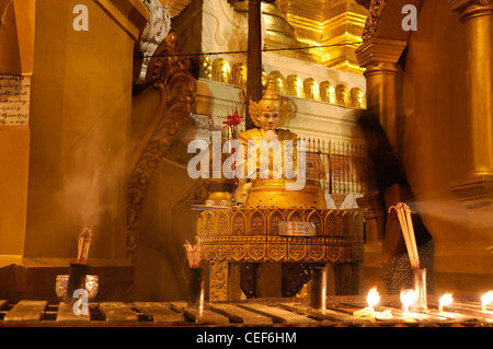 Fervent pèlerin pour verser de l'eau faisant offrande à la statue de Bouddha de la pagode Shwedagon post planétaire myanmar nuit nuit Banque D'Images