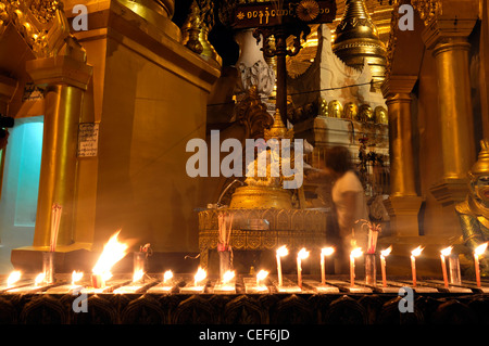 Fervent pèlerin pour verser de l'eau faisant offrande à la statue de Bouddha de la pagode Shwedagon post planétaire myanmar nuit nuit Banque D'Images