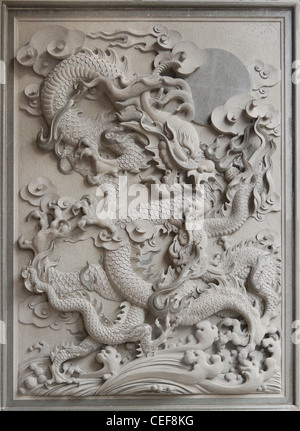 Dragon chinois de la sculpture sur pierre de granit sur mur extérieur du Temple Banque D'Images