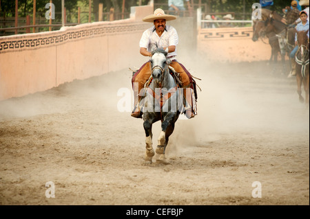 Charros mexicains cavalier galopant dans l'anneau, Texas, US Banque D'Images