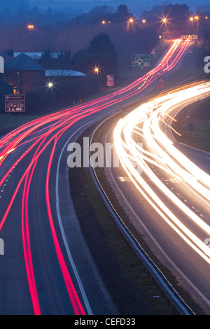 Les sentiers de la lumière de la circulation aux heures de pointe qui se déplacent le long de l'A69 en direction de la ville de Hexham, Northumberland, Angleterre Banque D'Images