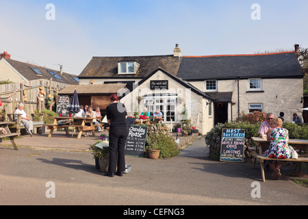 La boule de sorcière 15e siècle freehouse pub avec des gens assis à table pour manger à l'extérieur profitant du soleil. Lizard Cornwall England UK Grande-Bretagne Banque D'Images