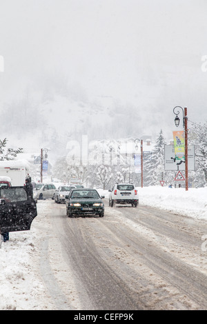 Les voitures qui circulent sur une route en mauvaise neige conditions météorologiques, Bourg St Maurice, France Banque D'Images