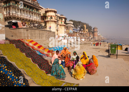 L'Inde, Uttar Pradesh, Varanasi, habillés de couleurs vives les pèlerins assis sur Reewal Ghat étapes ci-dessous Ganga Mahal Banque D'Images