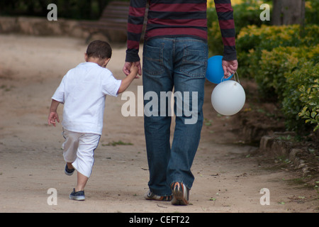 Retour de petit garçon et père de marcher dans le parc des ballons d Banque D'Images