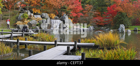 Les touristes dans le passage libre sur l'étang avec cascade et les érables en couleurs d'automne au jardin japonais, Hasselt, Belgique Banque D'Images