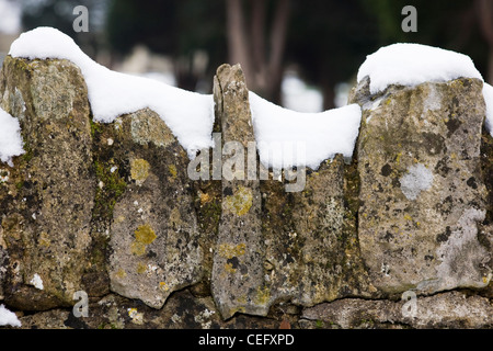 La neige au sommet d'un mur de pierres sèches. Banque D'Images