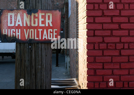 Rusty old "Attention : Haute Tension' signe sur un poteau, Brooklyn, New York Banque D'Images