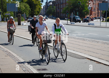 Les filles à vélo à Copenhague, au Danemark, sur l'une des nombreuses pistes cyclables le long des rues - à la gare Østerport, à Oslo Plads. Banque D'Images