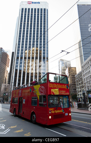 Une décapotable rouge City bus de tourisme de la conduite dans le quartier des affaires de Dan, Francisco. Banque D'Images