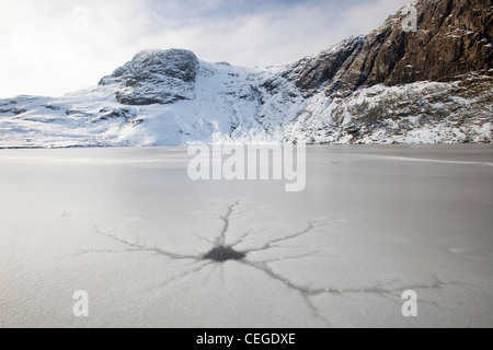 Un frozen Stickle Tarn avec les patrons des fissures dans la glace, au-dessus de la vallée de Langdale dans le Lake District, UK, Banque D'Images