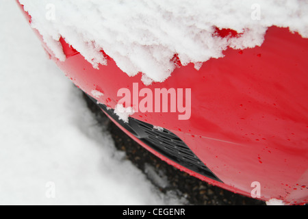 Close up de bumper détail de voiture rouge recouvert de neige vu de dessus Banque D'Images