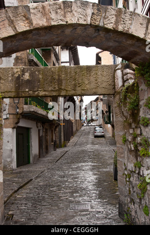 Scène de rue à Hondarribbia, Espagne, avec d'étroites rues pavées bordées de maisons médiévales. Banque D'Images