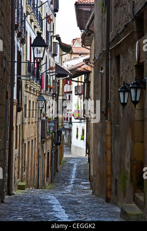 Scène de rue à Hondarribbia, Espagne, avec d'étroites rues pavées bordées de maisons médiévales. Banque D'Images