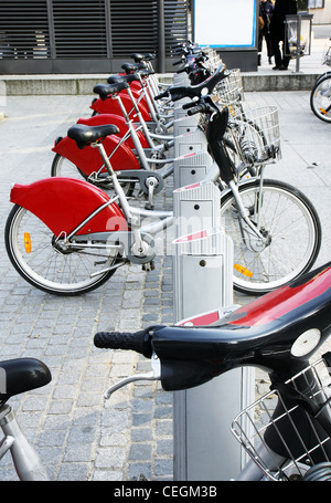 D'un autre moyen de transport : location de vélos garés à un poste devant un arrêt de bus dans la vieille ville européenne. Banque D'Images