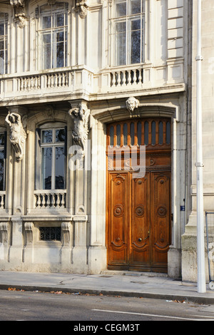 Belle porte en bois d'un vieil appartement européen de télévision bâtiment en pierre, avec des statues sculptées et balcons, Lyon, France. Banque D'Images