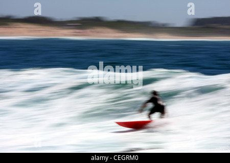 Surfer sur la vague du surf. Image panoramique montrant le mouvement de surfer sur une planche de surf en mer. Banque D'Images