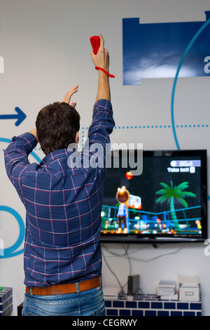 L'homme jouant sur la console Wii. Banque D'Images