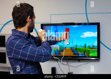 L'homme jouant sur la console Wii. Banque D'Images