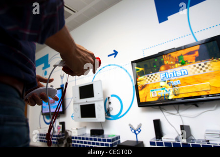 L'homme jouant sur la console Wii. Banque D'Images