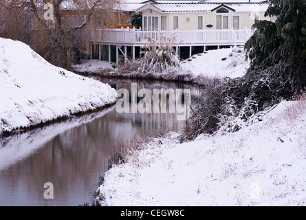 La campagne du Sussex de l'est avec un cours d'eau et maisons de vacances sur un hivers couvertes de neige hiver jour UK Banque D'Images