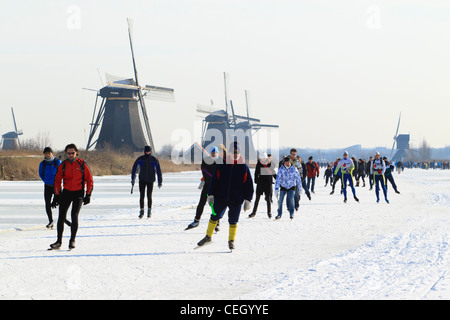 Scène typiquement néerlandais montrant les gens patinage sur glace naturelle avec les moulins à vent de Kinderdijk en toile de fond. Banque D'Images