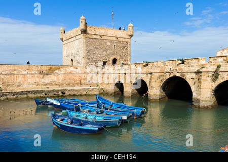 La tour de la Skala du port avec bateaux de pêche locaux dans l'avant-plan, Essaouira, Maroc, Afrique du Nord Banque D'Images