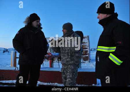 ADM. Arrière de garde-côtes Tom Ostebo discute des préparatifs qui ont été faits pour la livraison de combustible prévue à Nome avec le général Tom Katkus et Cmdr de la Garde nationale de l'Armée de l'Alaska. Scott Johnson au site de transfert de carburant du port de Nome le 13 janvier 2012. Ostebo et Katkus ont visité les installations et ont effectué un survol du garde-côte Healy et du pétrolier russe Renda. Banque D'Images